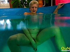 Gorgeous mature blonde Jitka is touching her shaved pussy in the pool